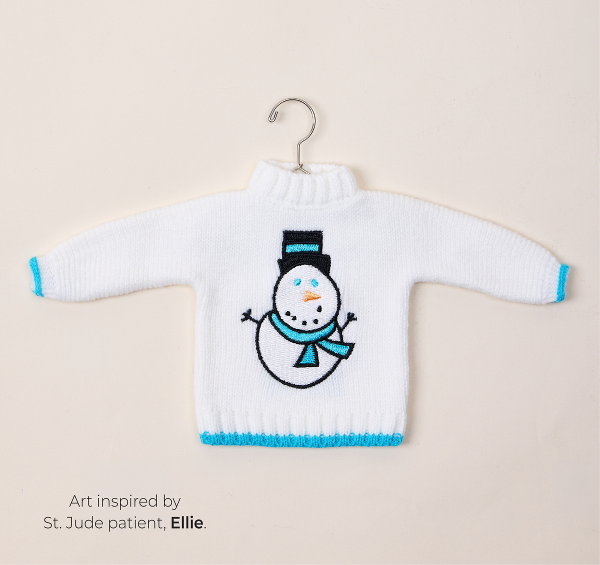 Featuring a white St. Jude Sweater Ornament. Art inspired by St. Jude patient, Ellie.